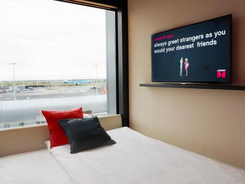 史基浦阿姆斯特丹史基浦机场世民酒店的卧室配有一张壁挂式平面电视的床。