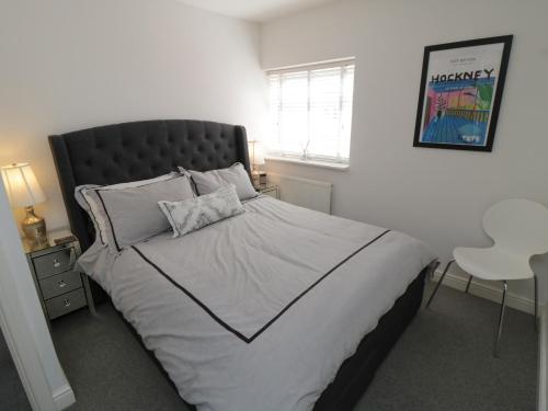 惠特比Flat 3, Peacehaven的一间卧室配有一张大床和黑色床头板