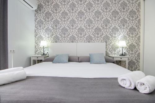 瓦伦西亚卡蒂亚环保住宿加早餐旅馆的卧室配有带毛巾的大型白色床