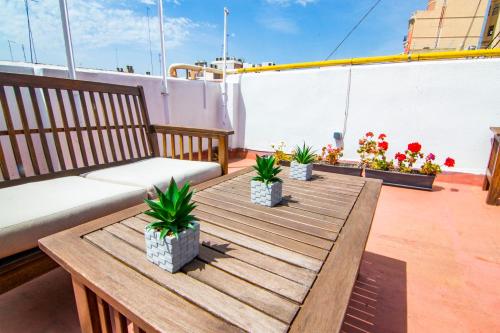 瓦伦西亚卡蒂亚环保住宿加早餐旅馆的阳台的木桌,配有沙发和植物