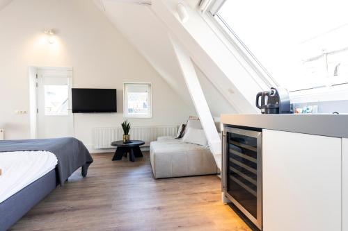 登堡Gravenstraat的一间卧室配有一张床、一台电视和一张沙发