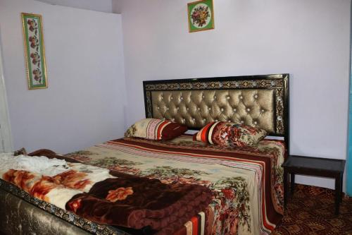 BaltitFort View Guest House的一间卧室配有一张床、软垫床头板和枕头