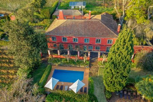 卡列塔葡萄园农场酒店的享有带游泳池的大型红色房屋的空中景致