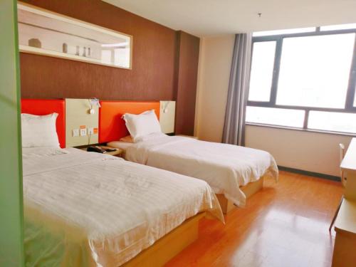 金昌7天酒店·金昌文化街店的酒店客房设有两张床和窗户。
