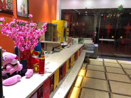 巴中7天酒店·巴中国际商贸城店的一间商店,上面有粉红色花卉的柜台
