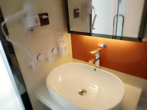 石嘴山7天优品·石嘴山大武口店的浴室设有白色水槽和镜子