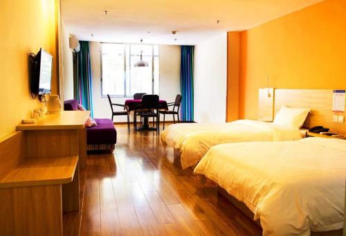Shuangjiang7天酒店·重庆云阳客运中心站店的酒店客房设有两张床和一张桌子。