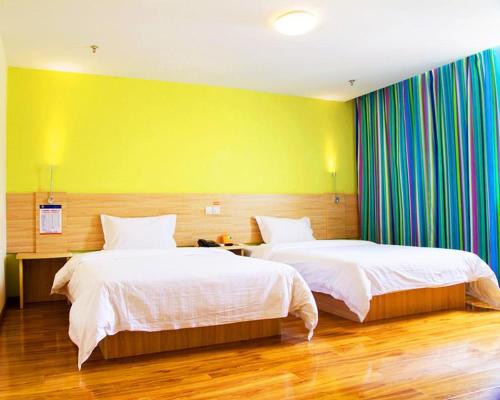Shuangjiang7天酒店·重庆云阳客运中心站店的一间卧室设有两张床和黄色的墙壁