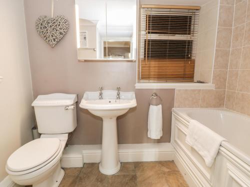 巴茅思Seaview Apartment的浴室配有卫生间、盥洗盆和浴缸。