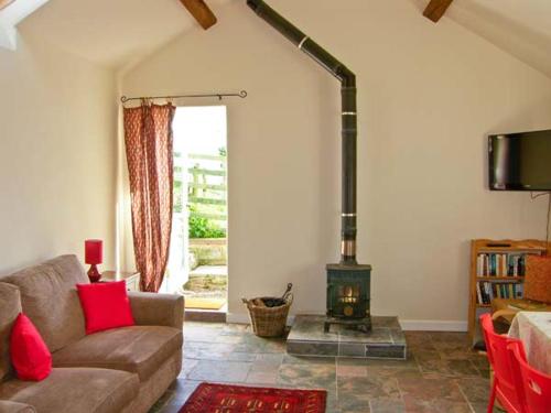 莫尔德Stone Cottage的带沙发和燃木炉的客厅