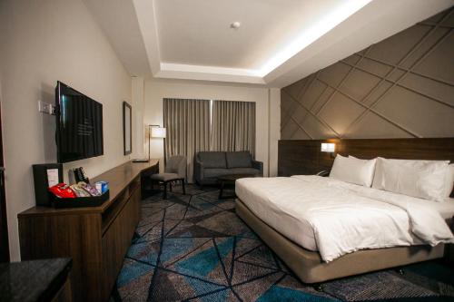 马尼拉鲁克森特酒店的配有一张床和一把椅子的酒店客房