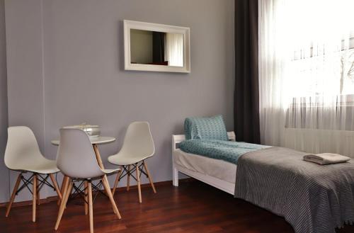 托伦巴耶波莫尔斯基剧院旅馆的卧室配有一张床和一张桌子及椅子
