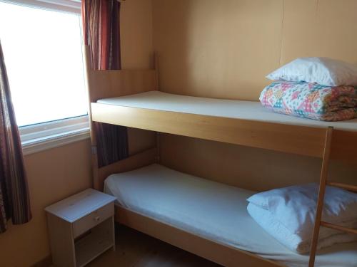 奥普达尔Magalaupe Camping的小房间设有两张双层床和窗户