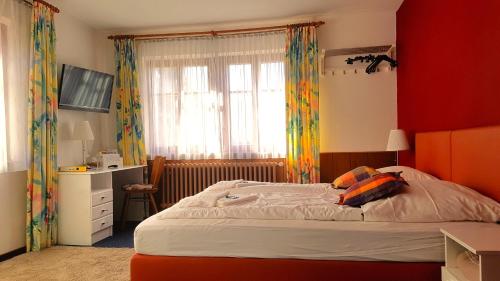 罗滕堡金色玫瑰精品酒店的一间卧室设有一张床和红色的墙壁