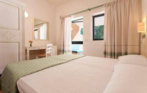 帕劳Camping Village Capo D'Orso的一间卧室设有两张床、一张桌子和一个窗口。