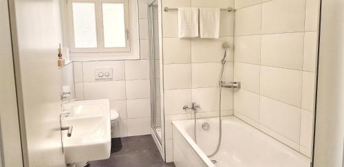卢塞恩Easy-Living Apartments Lindenstrasse 21的白色的浴室设有浴缸和水槽。