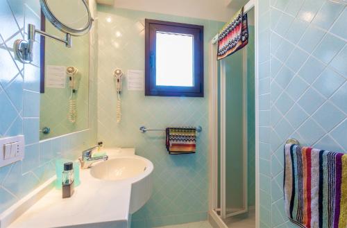 坎尼吉翁瓦坎泽伊苏莱达中央酒店的蓝色瓷砖浴室设有水槽和淋浴