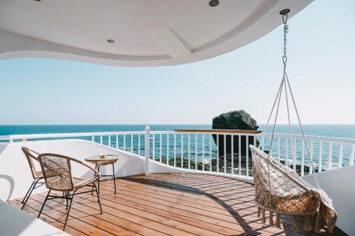鹅銮鼻草分木B&B • 垦丁船帆石的阳台配有两把椅子和一张桌子,享有海景。