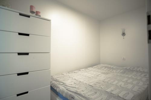 库瑞尼卡慕斯卡Maximus domki的一间白色卧室,配有一张床和一个梳妆台