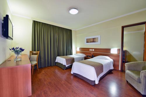 佩洛塔斯库瑞宫酒店的酒店客房设有两张床和一张桌子。