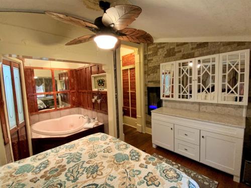 温泉城The Gables Inn的一间卧室配有一张床和一个浴缸,并提供吊扇