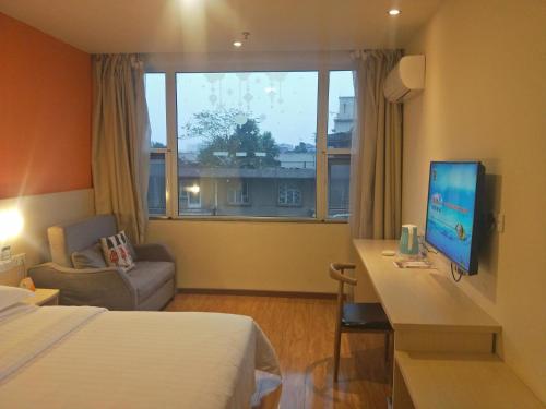 乐山7天酒店·峨眉山中心店的酒店客房配有一张床和一张书桌及一台电视