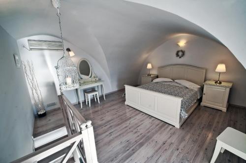 费拉Archontiko Suites Santorini的一间卧室配有一张床、一张桌子和一张桌子