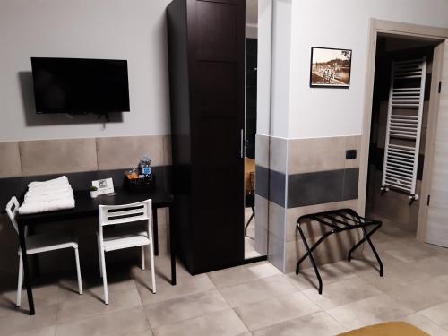 卡塞勒托瑞尼斯La Montrucca Camere的配有桌子、电视和桌椅的房间