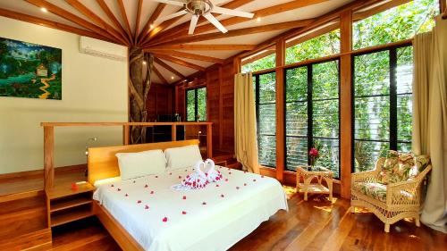 圣伊格纳西奥Vanilla Hills Lodge的一间卧室设有一张床和大窗户