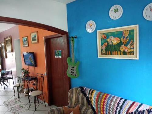 弗洛里亚诺波利斯Hospedaria Green的一间设有蓝墙、钟表和吉他的房间