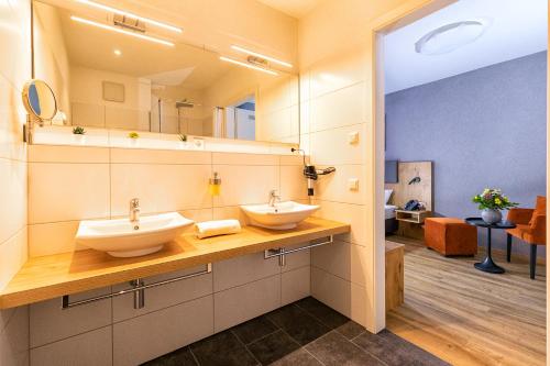 莱茵豪森Hotel La Mirabelle的一间带两个盥洗盆和大镜子的浴室