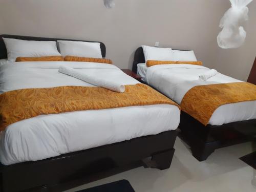 布兰太尔Delight Lodge的一间卧室配有两张带橙色和白色床单的床