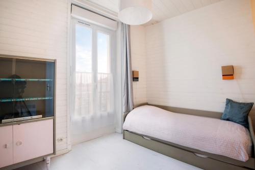 拉罗谢尔La Mariennée的一间卧室设有一张床和一个大窗户