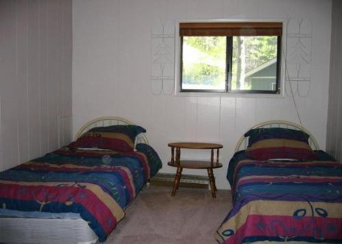 六月湖Birch Creek #8 - 2BR/1.5BA的配有桌子和窗户的客房内的两张床