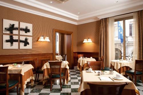 罗马马斯卡尼酒店的一间在房间内配有桌椅的餐厅