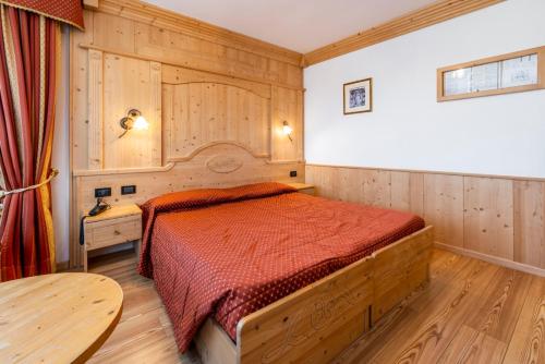 丰多LM Rooms的一间卧室配有一张红色床罩的床