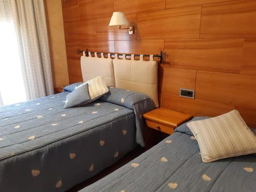 坎普罗东拉普拉克塔旅馆的木镶板客房内的两张床