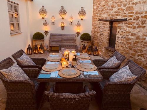 奇平卡姆登Jasmine Cottage的一间带木桌和椅子的用餐室
