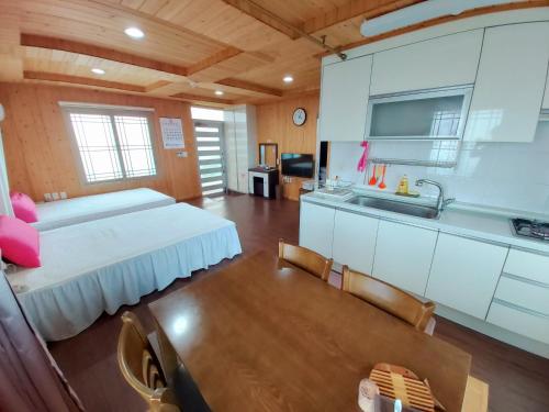 济州市感觉良好度假屋的配有床和厨房的大客房