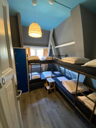 阿姆斯特丹阿姆斯特丹宇宙旅舍的一间设有四张双层床和一盏灯的房间