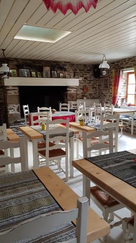 勒孔凯Auberge de Keringar的用餐室配有木桌和白色椅子