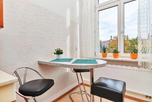 弗罗茨瓦夫Apartament Nowa 12的窗户间里的一张桌子和两把椅子