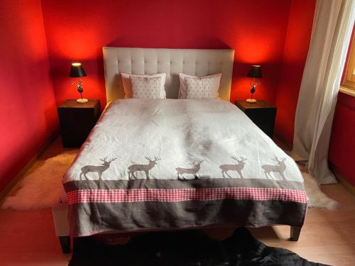 达沃斯Ferienwohnung Sunneschii的红色卧室,床上有四只鹿