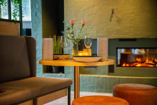 布莱尼Hotell Jæren的一张桌子、两杯酒和壁炉
