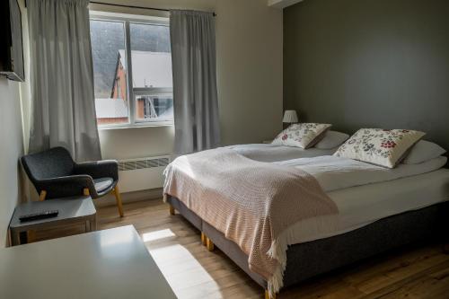 Bíldudalur海港住宿加早餐旅馆的卧室配有床、椅子和窗户。
