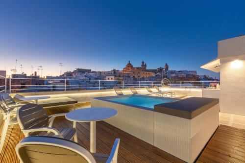 奥斯图尼Palazzo Mascetti Executive Rooms的阳台设有游泳池和桌椅。