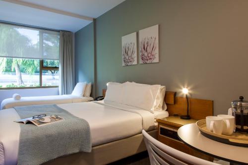 珀斯国王公园汽车旅馆的酒店客房设有两张床、一张桌子和一个窗户。