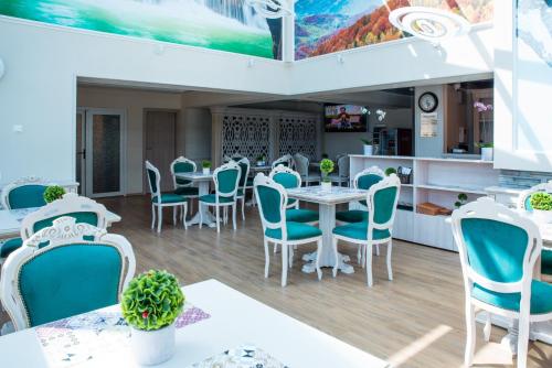 普雷代亚尔Park Luxury Rooms的一间在房间内配有蓝色椅子和桌子的餐厅