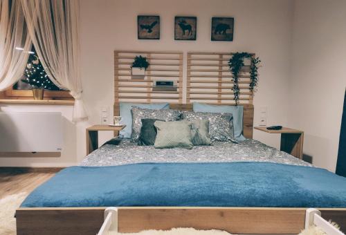 FalsztynApartament Borowikowe Zacisze的一间卧室配有一张大床,提供蓝色的床单和枕头