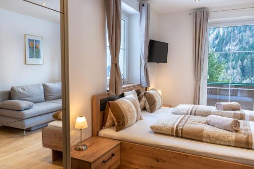 伦韦格沃德霍斯旅馆的一间卧室配有一张床、一张沙发和一个窗口